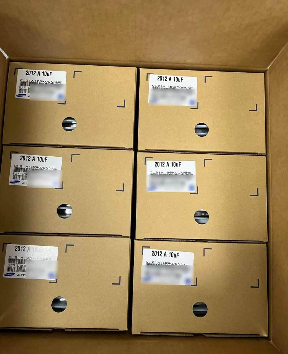 Six sealed manufacturer boxes of 2012 10 µF MLCC reels, 20,000 pcs each, with QC-passed labels inside a shipping carton
