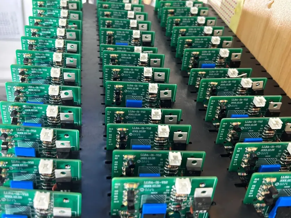 Rows of through-hole assembled boards with axial resistors, TO-220 packages on heatsinks and blue trimmer potentiometers